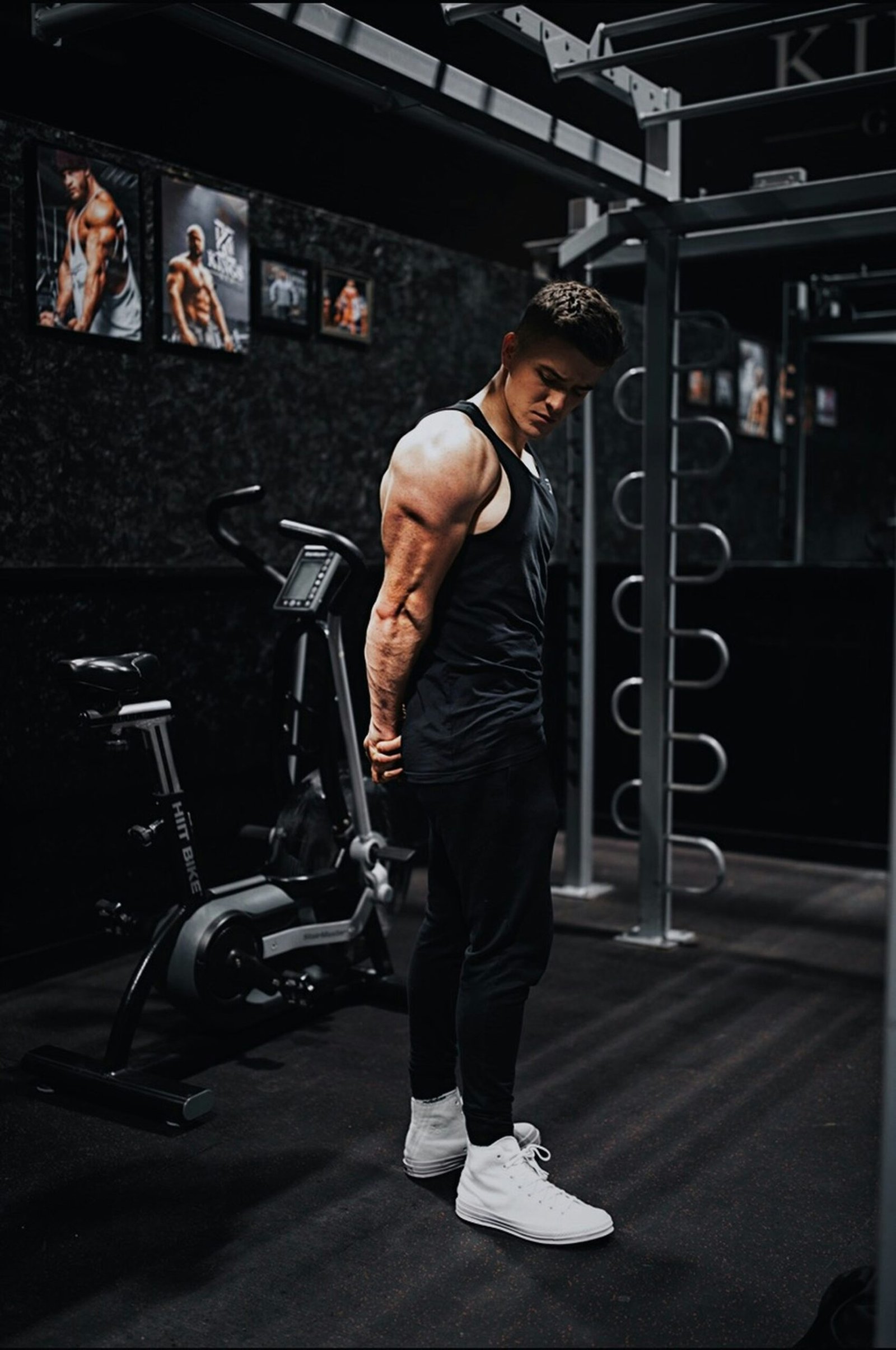 man in black tank top and black pants standing on black exercise equipment